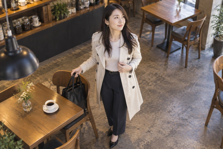 バッグを持ってカフェの席を立つ女性