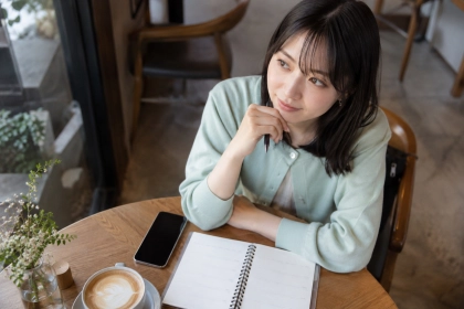 カフェで会う予定を考える女性