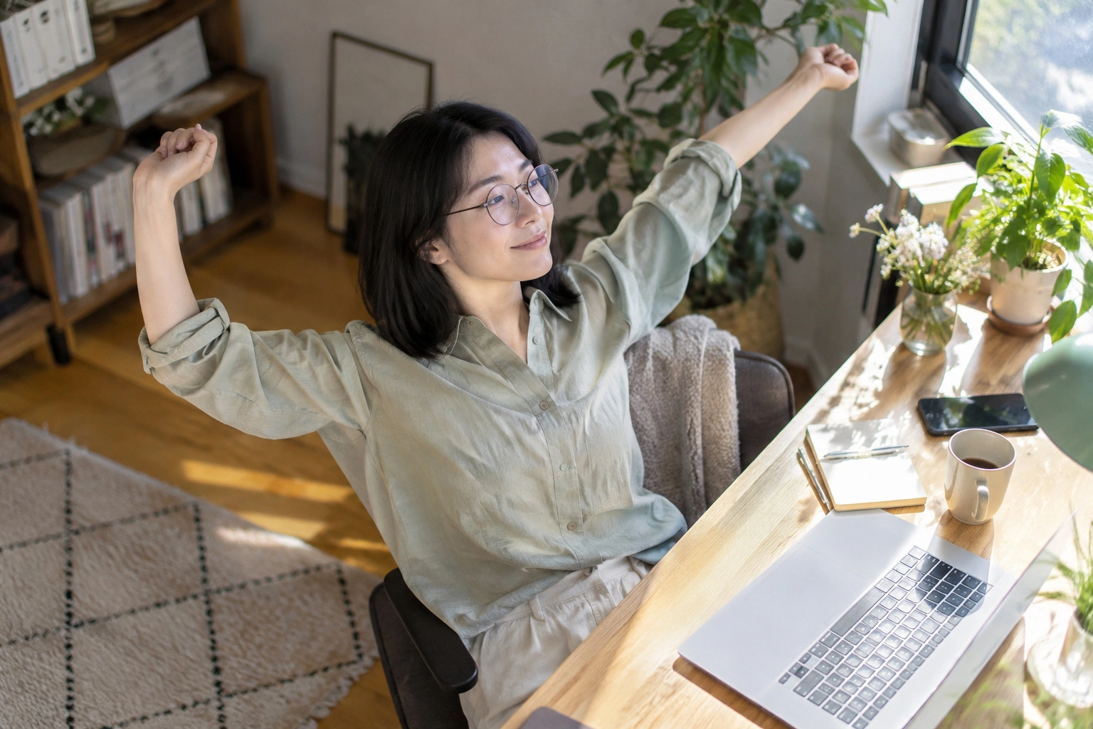 在宅勤務の合間に腕を伸ばす女性